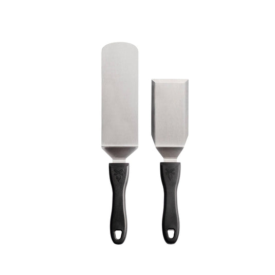 The Camp Chef Professional Chef Spatula Set includes two metal spatulas—a long, rounded pancake flipper and a short, rectangular turner with black handles—shown side by side on a white background.