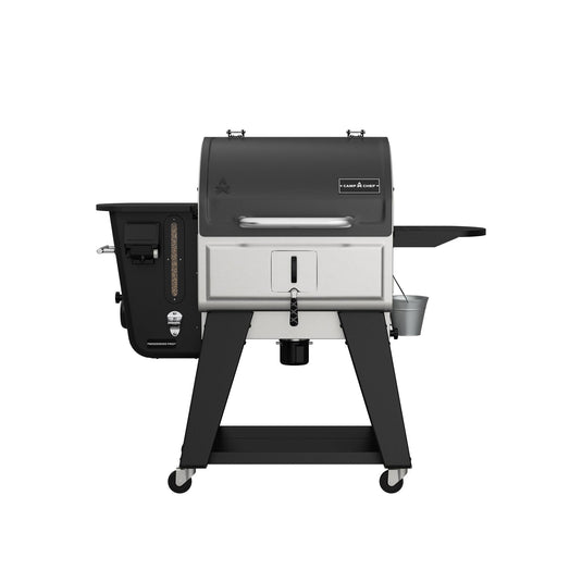 The Camp Chef Woodwind Pro 24 is a modern outdoor grill with a black and silver design, side shelf, temperature gauge, wood pellet hopper, storage hooks, small metal bucket underneath, and four wheels—ideal for grilling or cold smoking.