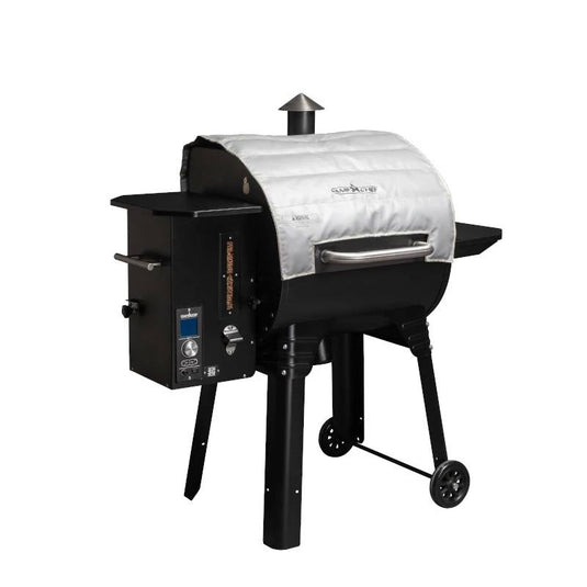 The Camp Chef Pellet Grill Blanket, shown against a white background, covers the main cooking area of a black outdoor pellet grill with a digital control panel and side shelf—ideal for cold weather grilling.