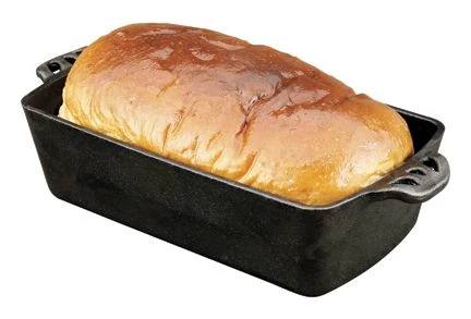 A golden-brown loaf rests in the Camp Chef Cast Iron Bread Pan, which is pre-seasoned for even heat distribution, shown against a white background.